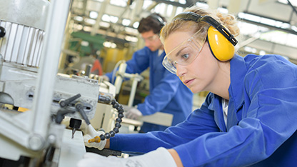 pracownik w środkach ochrony indywidualnej i zapewniający bezpieczeństwo, skupiony na zadaniu