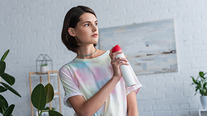 osoba rozpylająca odświeżacz powietrza